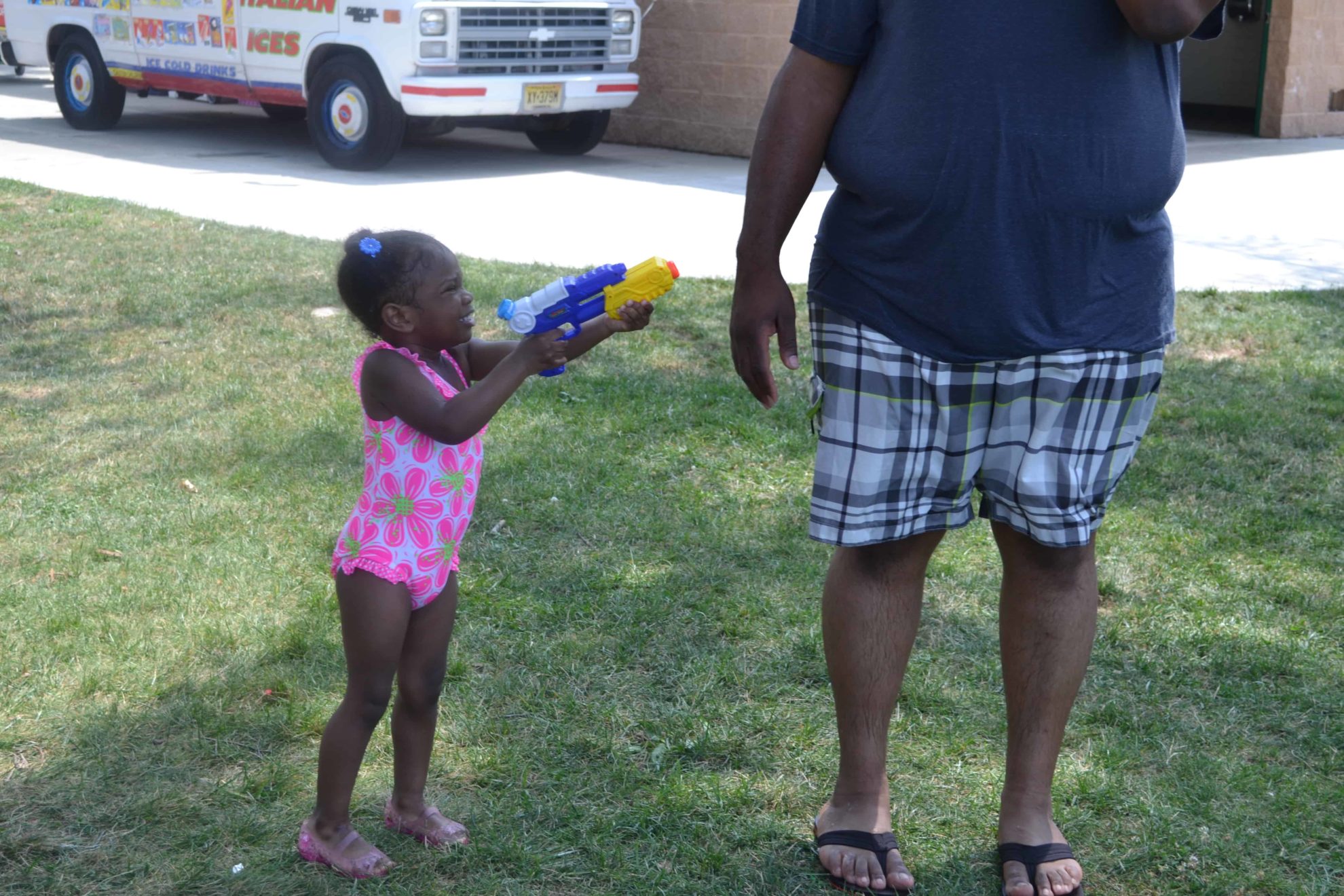 little girl shooting daddy with her water gun