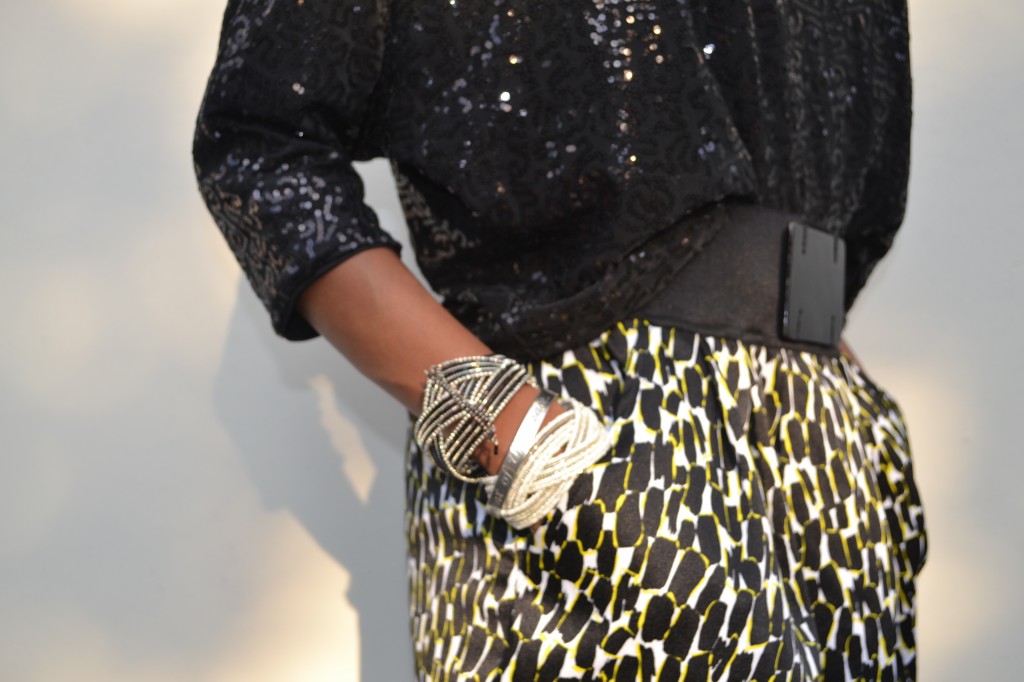 black sequin shirt, black, white and yellow skirt and "arm candy"