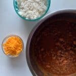 chili in an Instant pot, with a bowl of white rice and a bowl of shredded yellow cheddar cheese